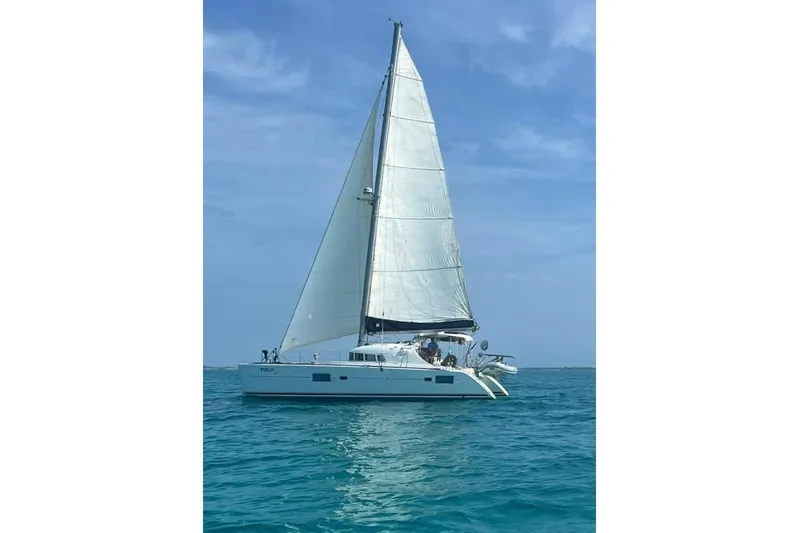 Yolo Yacht Photos Pics 2006 Lagoon 410-S2 catamaran sailing on clear blue ocean under a sunny sky.