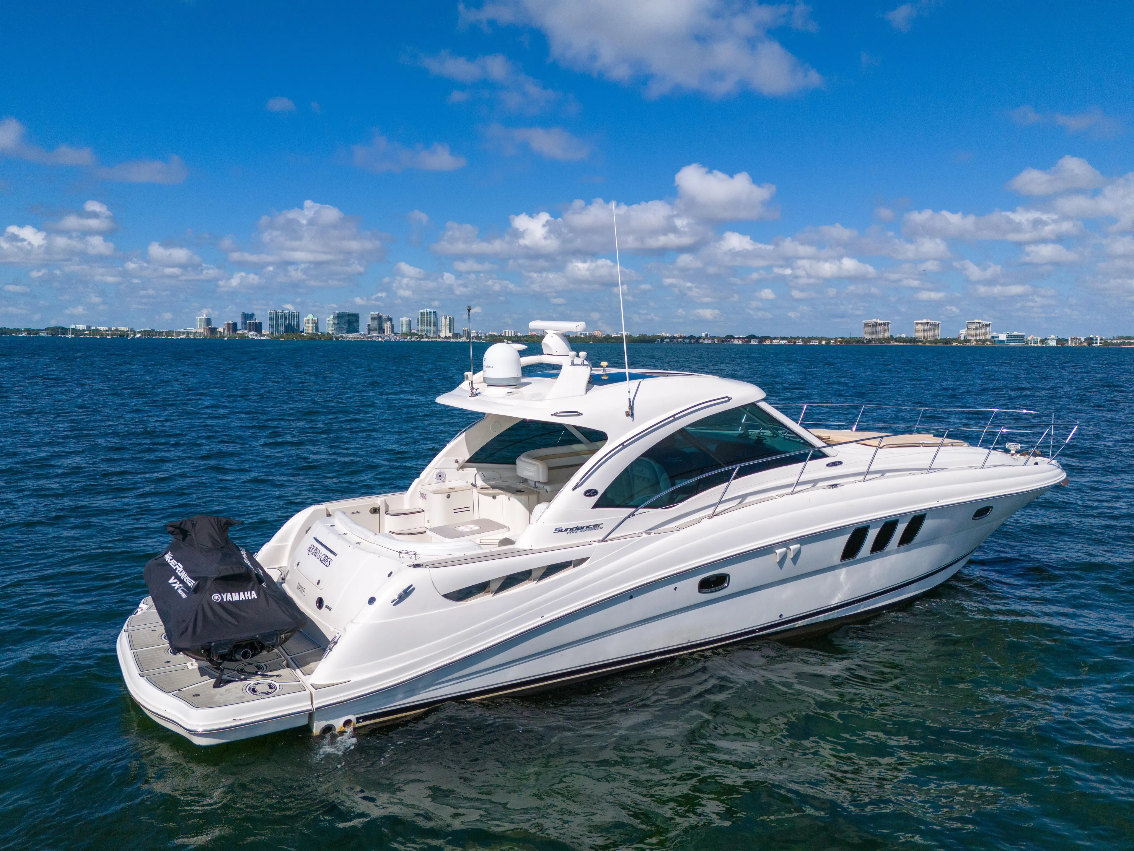  Yacht Photos Pics 2010 Sea Ray 500 Sundancer yacht on open water with city skyline in background.