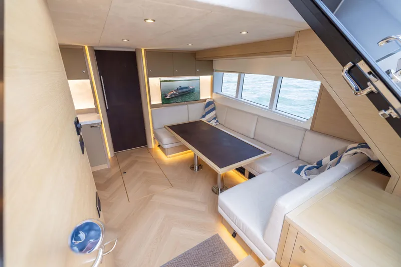 Grit Yacht Photos Pics Luxurious interior of 2025 Steeler Bronson 67 Beachclub yacht with modern seating and table.