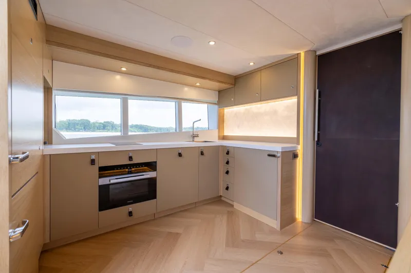 Grit Yacht Photos Pics Modern kitchen interior of 2025 Steeler Bronson 67 Beachclub yacht, featuring sleek cabinetry and lighting.