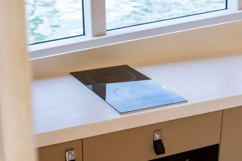 Grit Yacht Photos Pics Modern kitchen countertop with induction cooktop on Steeler Bronson 67 Beachclub yacht, 2025 model.