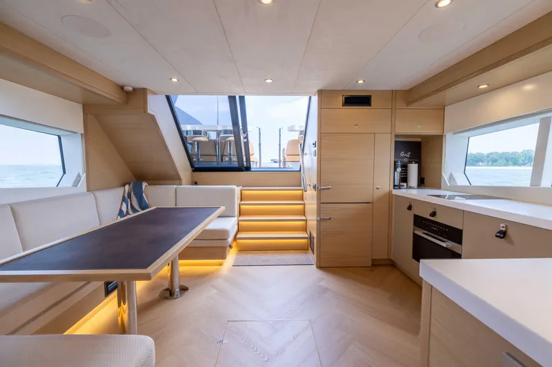 Grit Yacht Photos Pics Luxurious interior of 2025 Steeler Bronson 67 Beachclub yacht with modern kitchen and seating area.