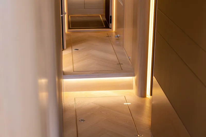Grit Yacht Photos Pics Luxurious interior hallway of 2025 Steeler Bronson 67 Beachclub yacht, featuring elegant lighting.