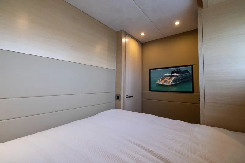 Grit Yacht Photos Pics Luxurious bedroom interior on 2025 Steeler Bronson 67 Beachclub yacht with TV display.