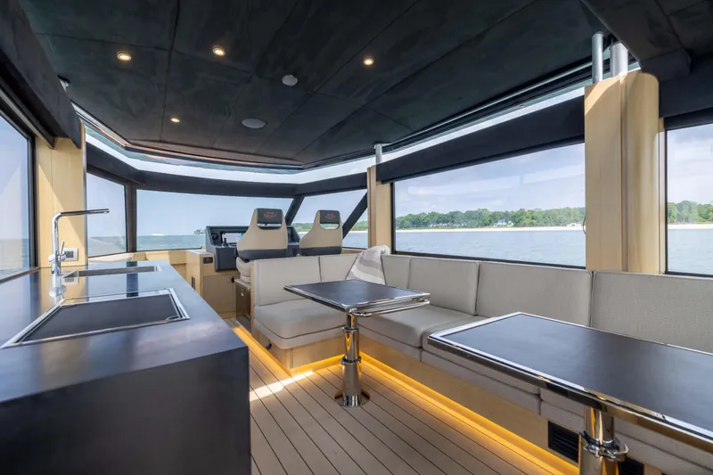 Grit Yacht Photos Pics Luxurious interior of 2025 Steeler Bronson 67 Beachclub yacht with modern seating and panoramic windows.