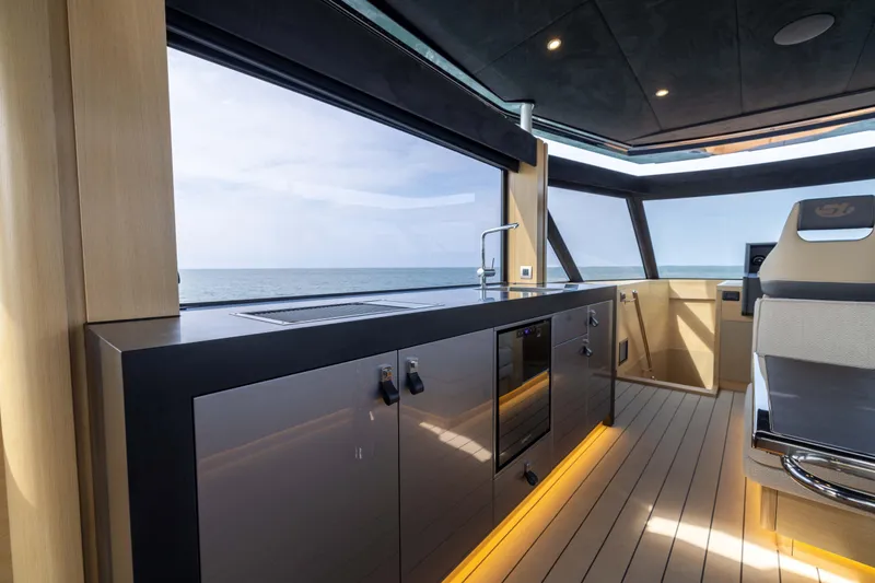 Grit Yacht Photos Pics Luxurious interior of 2025 Steeler Bronson 67 Beachclub yacht with modern kitchen and ocean view.