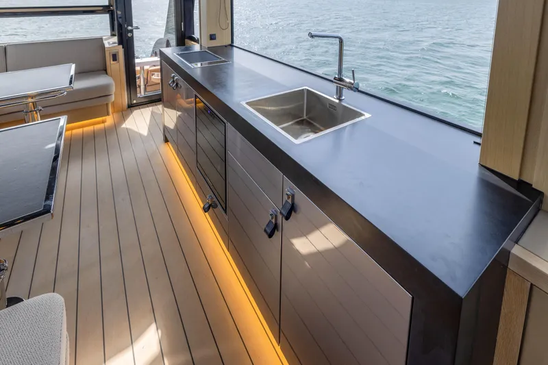 Grit Yacht Photos Pics Luxurious interior of 2025 Steeler Bronson 67 Beachclub yacht with modern kitchen and ocean view.