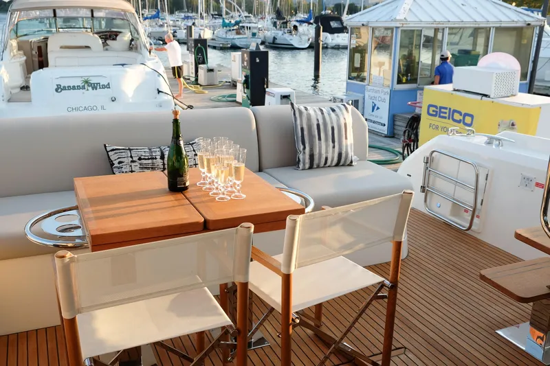  Yacht Photos Pics Luxurious 2021 Prestige 590 Sport Fly yacht deck with champagne and seating at marina.