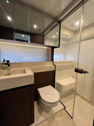  Yacht Photos Pics Luxurious bathroom in 2021 Prestige 590 Sport Fly yacht with modern fixtures and glass shower.