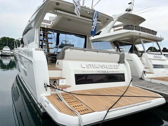  Yacht Photos Pics 2021 Prestige 590 Sport Fly yacht docked, featuring sleek design and wooden deck.