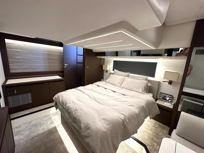  Yacht Photos Pics Luxurious bedroom interior of 2021 Prestige 590 Sport Fly yacht, featuring modern design and cozy bedding.