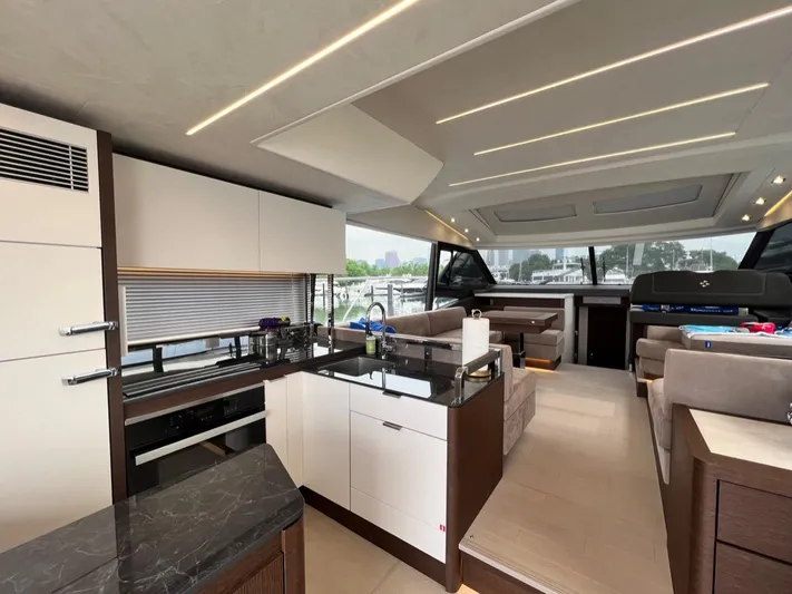  Yacht Photos Pics Luxurious interior of 2021 Prestige 590 Sport Fly yacht with modern kitchen and seating area.