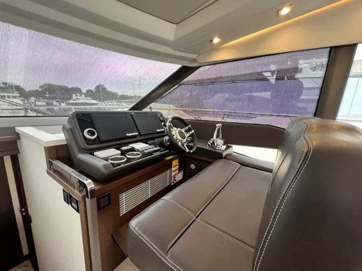  Yacht Photos Pics Luxurious helm station of 2021 Prestige 590 Sport Fly yacht with leather seating.