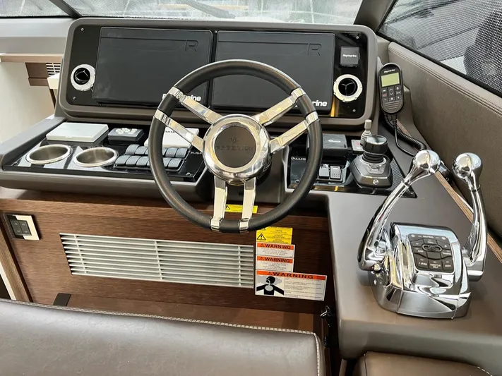  Yacht Photos Pics 2021 Prestige 590 Sport Fly yacht helm with steering wheel and control panel.