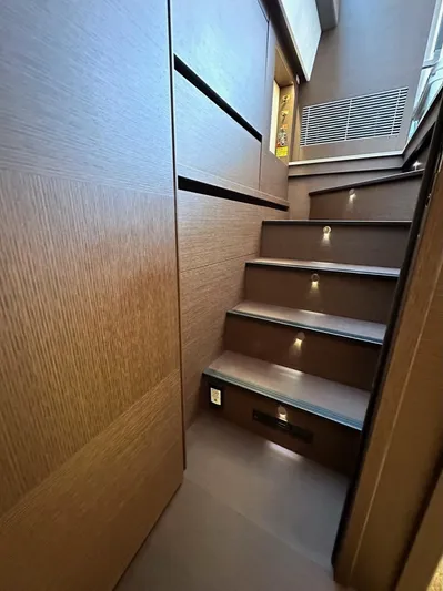  Yacht Photos Pics Staircase inside 2021 Prestige 590 Sport Fly yacht with modern wood finish and ambient lighting.