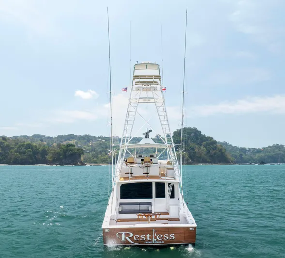 Relentless Yacht Photos Pics 2003 Viking 61 Convertible yacht on open water, rear view with lush coastline.