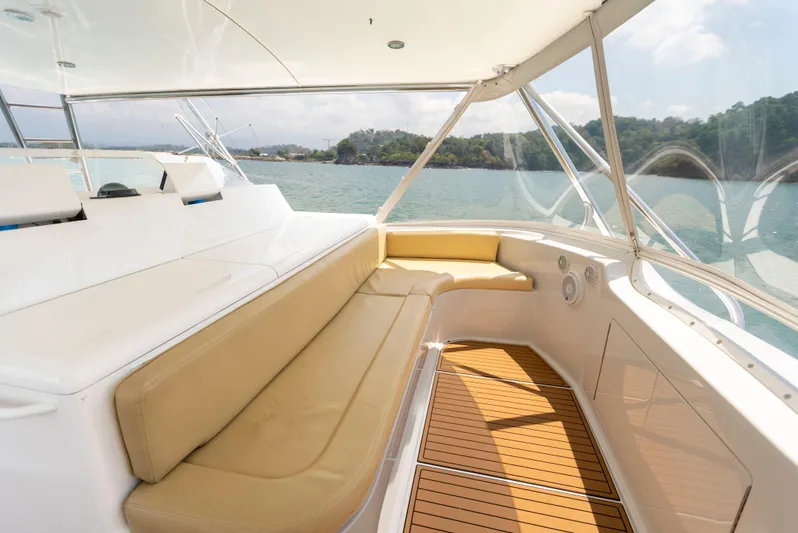 Relentless Yacht Photos Pics 2003 Viking 61 Convertible yacht interior with beige seating and wooden flooring, overlooking serene waters.