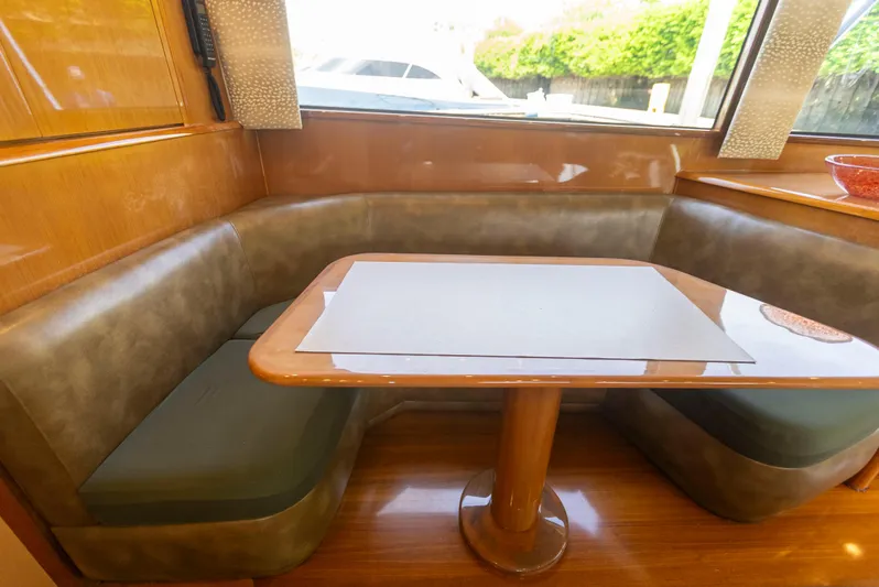 Relentless Yacht Photos Pics Luxurious dining area in a 2003 Viking 61 Convertible yacht with wood finish and cushioned seating.