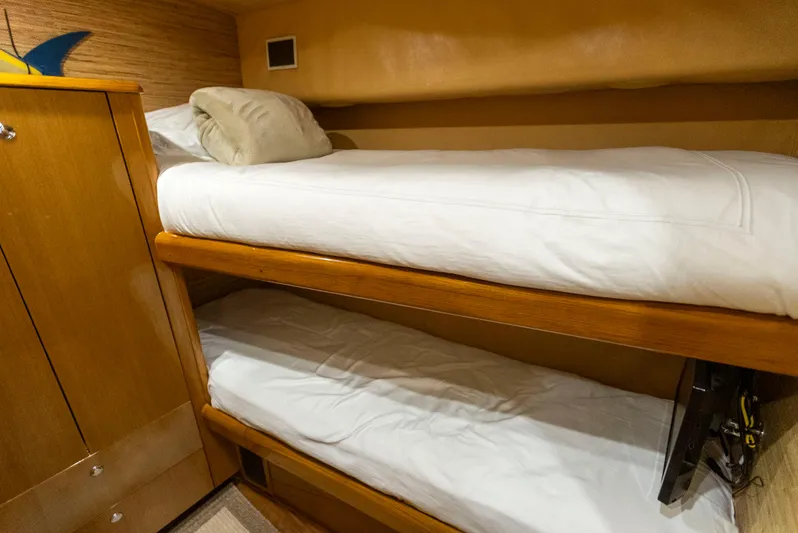 Relentless Yacht Photos Pics Bunk beds in 2003 Viking 61 Convertible yacht cabin, featuring wooden finish and white bedding.