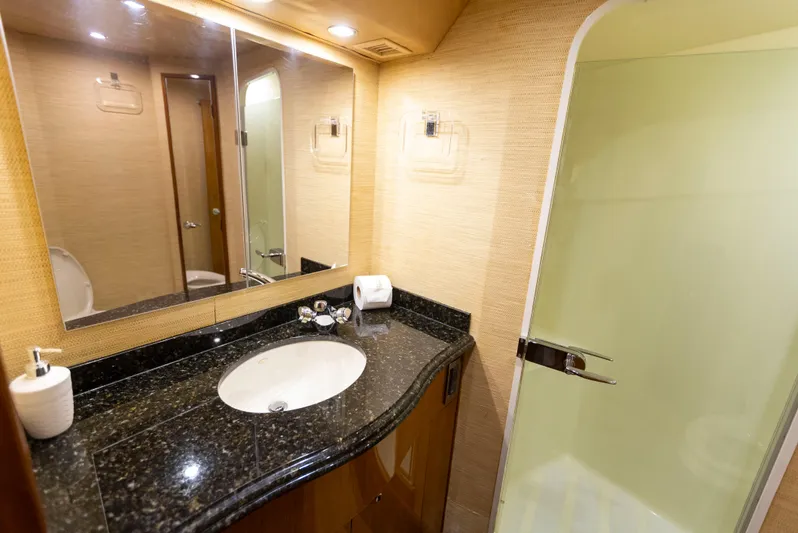 Relentless Yacht Photos Pics Luxurious bathroom in 2003 Viking 61 Convertible yacht with granite countertop and glass shower.