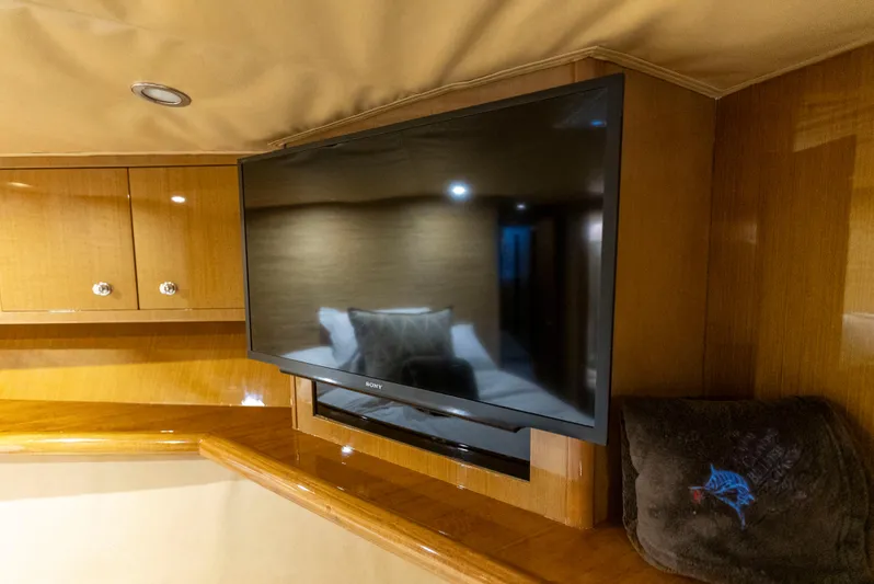 Relentless Yacht Photos Pics 2003 Viking 61 Convertible yacht interior with mounted TV and wooden cabinetry.