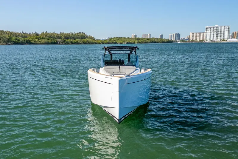 Bote Coco Yacht Photos Pics 2023 Pardo Yachts P38 cruising on calm waters with city skyline in background.