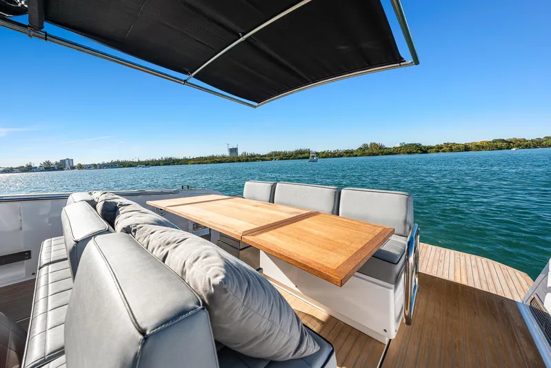 Bote Coco Yacht Photos Pics Luxurious 2023 Pardo Yachts P38 deck with seating, table, and scenic water view.