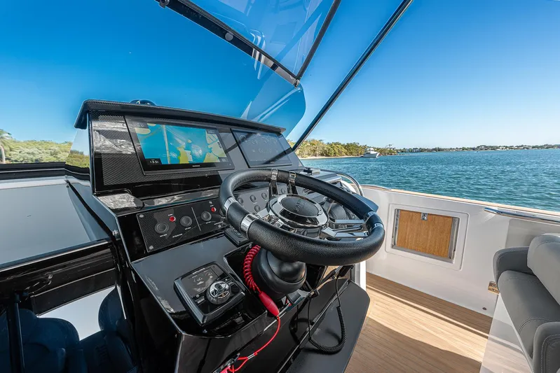 Bote Coco Yacht Photos Pics Helm of 2023 Pardo Yachts P38 with navigation screen, steering wheel, and ocean view.