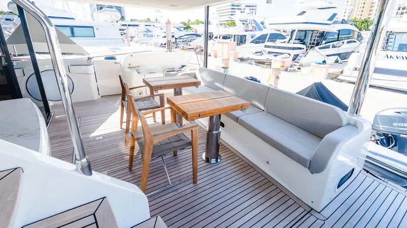 Available Now Yacht Photos Pics Outdoor seating area on 2024 Absolute 68 NAVETTA yacht, featuring wooden table and chairs.