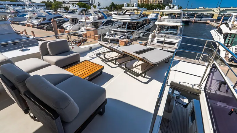 Available Now Yacht Photos Pics Luxurious 2024 Absolute 68 NAVETTA yacht deck with lounge chairs and marina view.