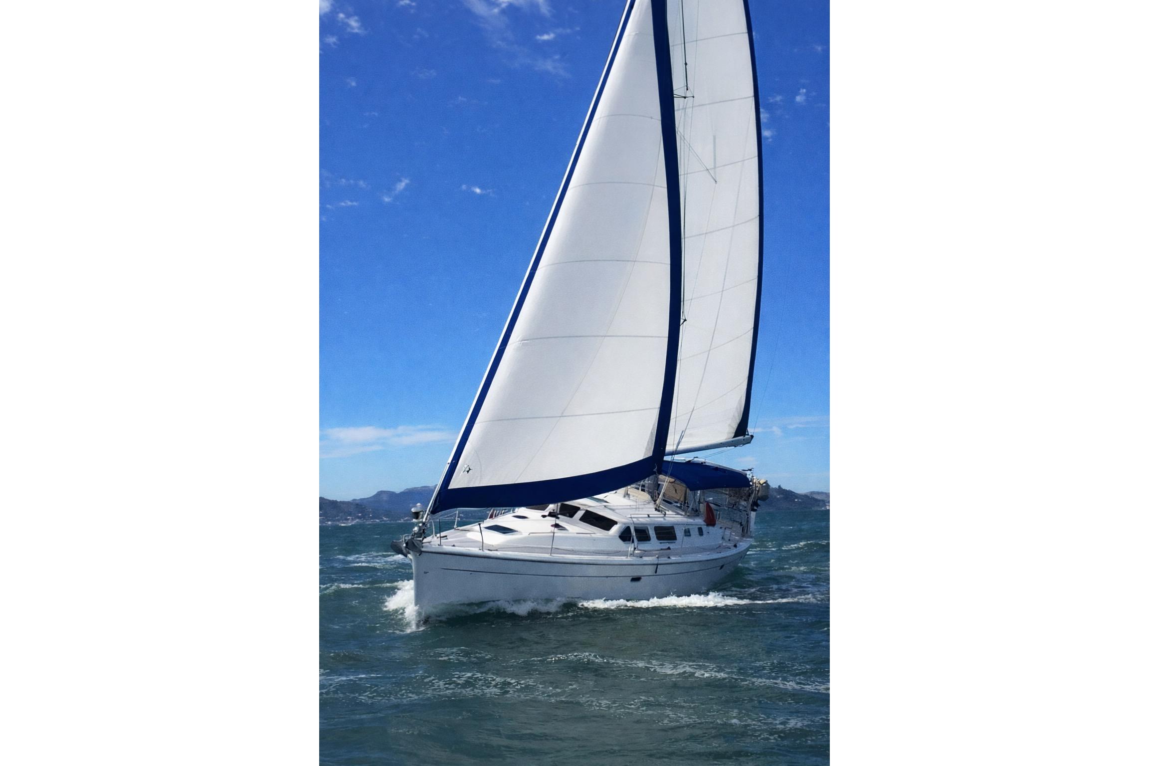 2007 Hunter 44 Deck Salon sailboat navigating open waters under clear blue skies.