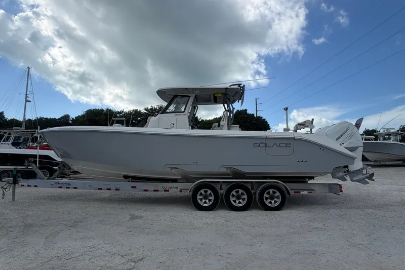  Yacht Photos Pics 2023 Solace 32 CS boat on trailer under cloudy sky, side view.