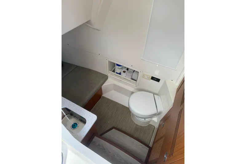  Yacht Photos Pics 2023 Solace 32 CS boat interior with compact bathroom and sink area.