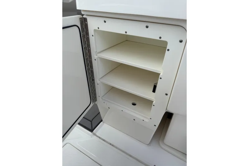  Yacht Photos Pics Open storage compartment in 2023 Solace 32 CS boat, featuring three shelves.