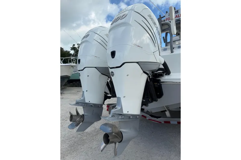  Yacht Photos Pics 2023 Solace 32 CS boat with twin Mercury outboard engines, parked on gravel.