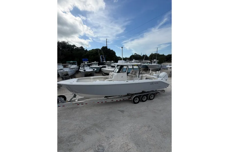  Yacht Photos Pics 2023 Solace 32 CS boat on trailer, parked in a marina under a blue sky.