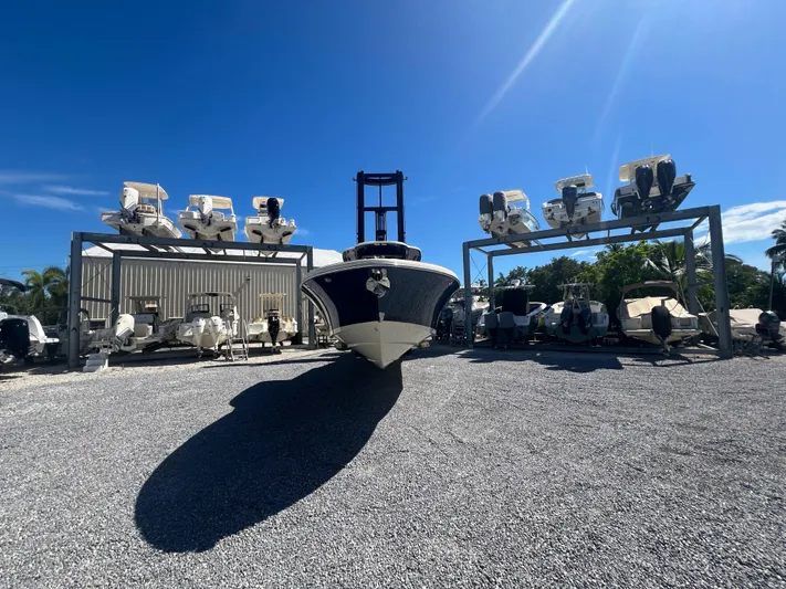  Yacht Photos Pics 2024 Chris-Craft Catalina 30 boat in storage yard under clear blue sky.