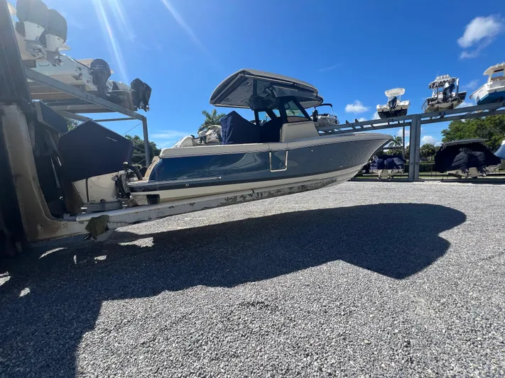  Yacht Photos Pics 2024 Chris-Craft Catalina 30 boat on a lift under a clear blue sky.