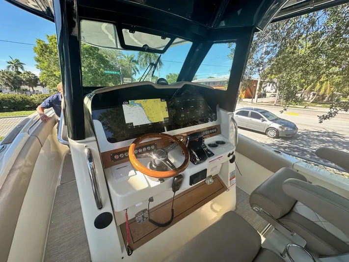  Yacht Photos Pics 2024 Chris-Craft Catalina 30 helm station with modern navigation equipment and wooden steering wheel.