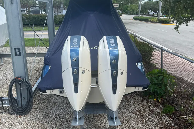  Yacht Photos Pics 2024 Chris-Craft Catalina 30 with twin outboard engines, covered and parked on gravel.