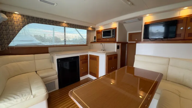 A-plus Yacht Photos Pics Luxurious interior of a 2003 Cabo 35 Flybridge Sportfisher with seating, kitchenette, and entertainment area.