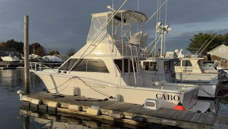 A-plus Yacht Photos Pics 2003 Cabo 35 Flybridge Sportfisher docked at marina, side view.