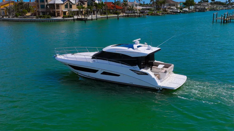 Just In Time Yacht Photos Pics 2016 Sea Ray 470 Sundancer yacht cruising in clear blue waters near luxury waterfront homes.