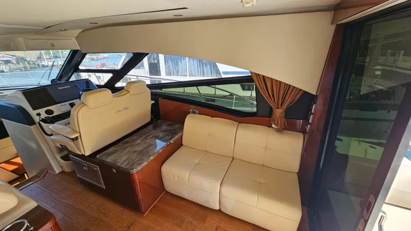 Just In Time Yacht Photos Pics Interior of 2016 Sea Ray 470 Sundancer yacht with beige seating and helm station.