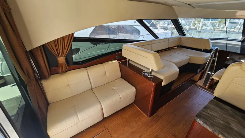 Just In Time Yacht Photos Pics Interior of 2016 Sea Ray 470 Sundancer yacht with beige leather seating and wooden flooring.