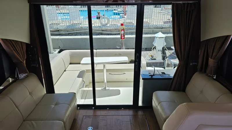 Just In Time Yacht Photos Pics Interior view of 2016 Sea Ray 470 Sundancer yacht with beige seating and glass doors.