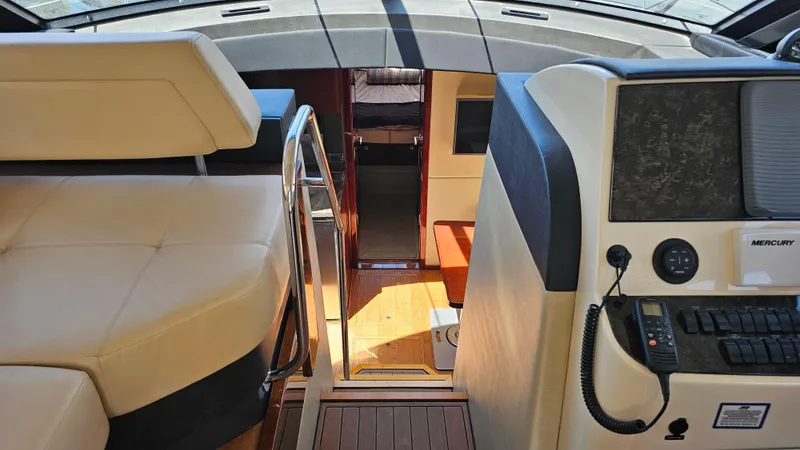 Just In Time Yacht Photos Pics Interior view of 2016 Sea Ray 470 Sundancer yacht, featuring helm and seating area.