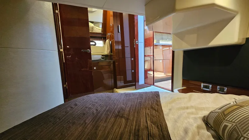 Just In Time Yacht Photos Pics Interior cabin of 2016 Sea Ray 470 Sundancer yacht, featuring luxurious bedding and wood finishes.