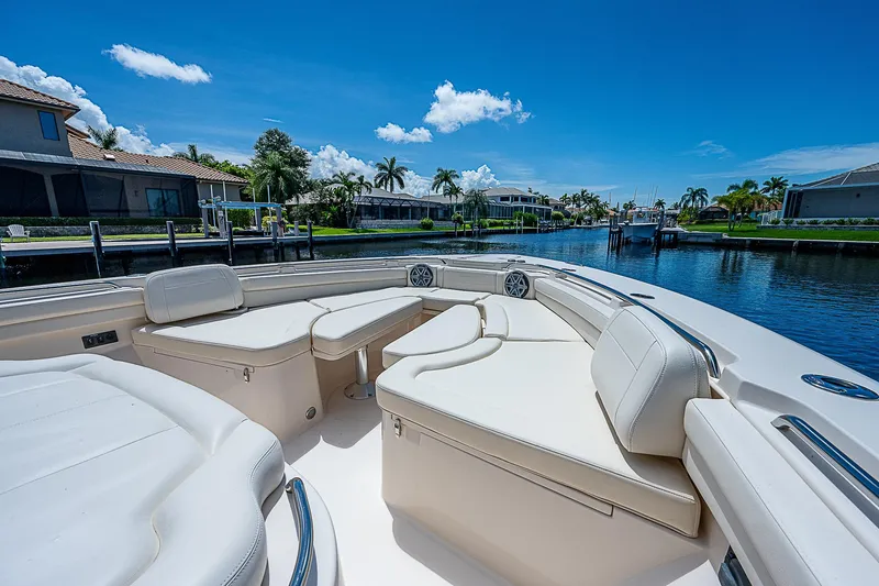  Yacht Photos Pics 2019 Grady-White Canyon 456 boat with luxurious seating, docked in a scenic waterfront area.