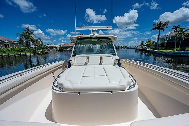  Yacht Photos Pics 2019 Grady-White Canyon 456 boat on a sunny day with blue skies and palm trees.